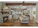 Beautiful living room with stone fireplace, beamed ceilings, and open layout to the dining area at 1193 River Rd, Johns Island, SC 29455