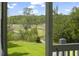 Expansive marsh view through screened porch featuring a long wooden walkway and vibrant green lawn at 1193 River Rd, Johns Island, SC 29455