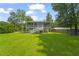 Backyard view showcasing a two-story home with a screened porch and a well-maintained lawn at 1193 River Rd, Johns Island, SC 29455