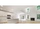 Open-concept kitchen and living area with white cabinets, stainless steel appliances, and abundant natural light at 124 Palfrey Dr, Ridgeville, SC 29472