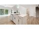 Open kitchen with island, white cabinets, modern appliances, and hardwood floors leading to a living area at 124 Palfrey Dr, Ridgeville, SC 29472