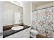 Bathroom with a dark vanity, white sink, and shower-tub combination, decorated with a leaf patterned curtain at 1300 Park West Blvd # 822, Mount Pleasant, SC 29466