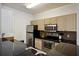 Modern kitchen with stainless steel appliances and dark countertops, open to dining area at 1300 Park West Blvd # 822, Mount Pleasant, SC 29466