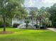 Beautiful two-story home featuring a wrap-around porch, staircase entry, and expansive green front lawn at 1447 Headquarters Plantation Dr, Johns Island, SC 29455