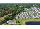 Aerial view of backyard home bordering a lake, showcasing lush landscaping, grassy lawns, and mature tree coverage at 1484 Milldam Pass, Johns Island, SC 29455