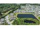 Aerial view of homes near a lake, featuring private pools and manicured lawns surrounded by verdant trees and foliage at 1484 Milldam Pass, Johns Island, SC 29455