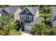 Aerial view of the two-story home with a well-kept lawn and a two-car garage at 1484 Milldam Pass, Johns Island, SC 29455