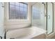 Bright bathroom featuring a garden tub and a glass-enclosed shower, offering a spa-like experience at 1484 Milldam Pass, Johns Island, SC 29455