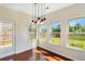 Bright dining area boasts elegant lighting, hardwood floors, and views of the backyard at 1484 Milldam Pass, Johns Island, SC 29455