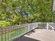 View of the outdoor wooden back deck with white railing and lush green foliage in the background at 1491 Greenshade Way, Mount Pleasant, SC 29464