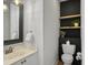 Modern half bathroom with a custom sink, black accent wall and wood shelving at 1491 Greenshade Way, Mount Pleasant, SC 29464