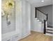 Bright foyer features a built-in bench with storage, a wood floor, and stairs to the upper level at 1491 Greenshade Way, Mount Pleasant, SC 29464