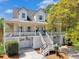 Charming home featuring a welcoming double decker porch, stairs, and two garage doors at 1491 Greenshade Way, Mount Pleasant, SC 29464
