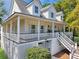 Charming white two-story home with a spacious front porch, blue shutters, and mature landscaping at 1491 Greenshade Way, Mount Pleasant, SC 29464