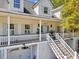 Detailed view of charming home with a double-decker porch, stairs, and two garage doors at 1491 Greenshade Way, Mount Pleasant, SC 29464