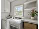 Bright laundry room with white cabinets, shelving, and stainless steel washer and dryer at 1491 Greenshade Way, Mount Pleasant, SC 29464