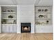 Cozy living room featuring a fireplace with built-in shelving and beautiful hardwood floors at 1491 Greenshade Way, Mount Pleasant, SC 29464
