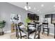 Elegant dining area with dark wood table set for six, stylish lighting, and adjacent kitchen with stainless appliances at 1523 Nautical Chart Dr, Charleston, SC 29414