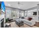 Bright living room with fireplace, hardwood floors, a large TV, and lots of natural light from many windows at 1523 Nautical Chart Dr, Charleston, SC 29414