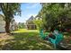 Relaxing backyard space with a fire pit and Adirondack chairs, surrounded by lush greenery and mature trees at 1625 Teal Marsh Rd, Charleston, SC 29412