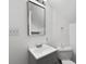 This bathroom has a white sink, toilet and walls. A plain square mirror hangs on the wall at 1625 Teal Marsh Rd, Charleston, SC 29412