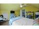 Bedroom with a white ceiling fan, a bed with a white frame and bedding and yellow walls at 1625 Teal Marsh Rd, Charleston, SC 29412