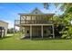 Coastal home with a spacious, shaded porch and a well-manicured lawn, perfect for outdoor living at 1625 Teal Marsh Rd, Charleston, SC 29412