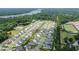 An aerial view showing community homes near a pond, green spaces, and a school with an athletic field at 2064 Parish House Cir, Johns Island, SC 29455