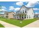 Inviting two-story home with a classic front porch, lush green lawn, and sidewalk at 2064 Parish House Cir, Johns Island, SC 29455