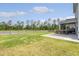 Expansive backyard featuring a covered patio, wooden furniture set, and a fence-lined pond at 209 Parkwood Vista Way, Summerville, SC 29486