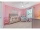 Charming bedroom painted pink, complete with crib, soft chair, and window at 209 Parkwood Vista Way, Summerville, SC 29486