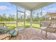 Screened porch area furnished with stylish, cushioned wicker seating, a rug, and views of the expansive yard at 209 Parkwood Vista Way, Summerville, SC 29486