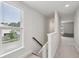 Bright hallway with staircase, large window, and view into playroom at 2267 Kemmerlin St, Johns Island, SC 29455