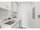 Modern laundry room with white cabinets, a front-loading washer and dryer, and functional storage solutions at 2267 Kemmerlin St, Johns Island, SC 29455