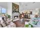 Open-concept living room featuring a fireplace, elegant furnishings, and an open view into the modern kitchen and dining area at 250 Little Oak Island Dr, Folly Beach, SC 29439