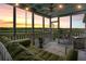 Relaxing screened porch with a comfortable daybed, swing and views of the marsh and water at 250 Little Oak Island Dr, Folly Beach, SC 29439
