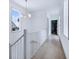 Hallway with hardwood floors, view of a blue house through a window and a closet at 29 Hanover St, Charleston, SC 29403