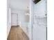 Hallway with stacked washer and dryer, hardwood floors and natural light from the window at 29 Hanover St, Charleston, SC 29403