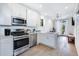 Modern kitchen with stainless steel appliances, white cabinetry, and a view into the adjacent living area at 29 Hanover St, Charleston, SC 29403