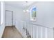 Bright staircase area with hardwood floors, white banister and natural light from the window at 29 Hanover St, Charleston, SC 29403