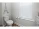 Elegant half bathroom with a toilet, white vanity, and a window with blinds at 290 Woodland Oak Way, Summerville, SC 29485