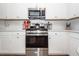 Bright kitchen features stainless steel appliances, white cabinets, and a white tile backsplash at 290 Woodland Oak Way, Summerville, SC 29485