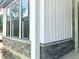New home exterior showcasing board and batten siding with stone foundation and black framed windows at 3006 Abagail Ct, North Charleston, SC 29406