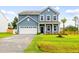 Charming two-story home exhibiting manicured lawn, blue siding, and a well-lit two car garage and driveway at 3010 Grinnell St, Johns Island, SC 29455