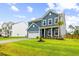 Inviting two-story home with manicured lawn, beautiful blue siding, a well-lit garage, and a well kept lawn at 3010 Grinnell St, Johns Island, SC 29455