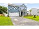 Charming two-story home showcasing manicured lawn, blue siding, and a well-lit two car garage and driveway at 3010 Grinnell St, Johns Island, SC 29455