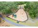 Aerial view of a charming playground with swings and slides, nestled among the trees, surrounded by mulch and a black fence at 3010 Grinnell St, Johns Island, SC 29455