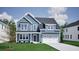 Charming two-story home featuring blue siding, a welcoming front porch, and an attached two-car garage at 3033 Seaton Street, Summerville, SC 29486