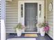 Close-up of the front door with a welcome mat, surrounded by potted flowers at 350 Arlington Dr, Charleston, SC 29414