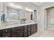 Elegant bathroom featuring a double vanity with dark cabinets and a view of a shower with a glass partition at 366 Tupelo Lake Dr, Summerville, SC 29486